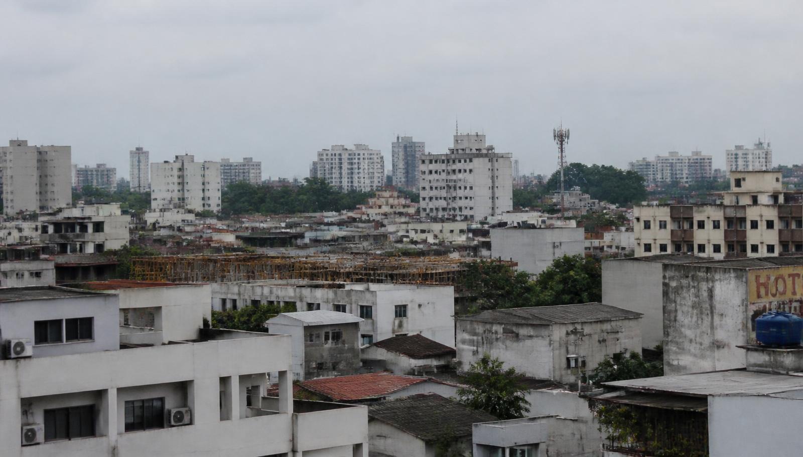 Vista de cobertura com conjunto de edifícios residenciais, reservatórios e antenas em dia nublado